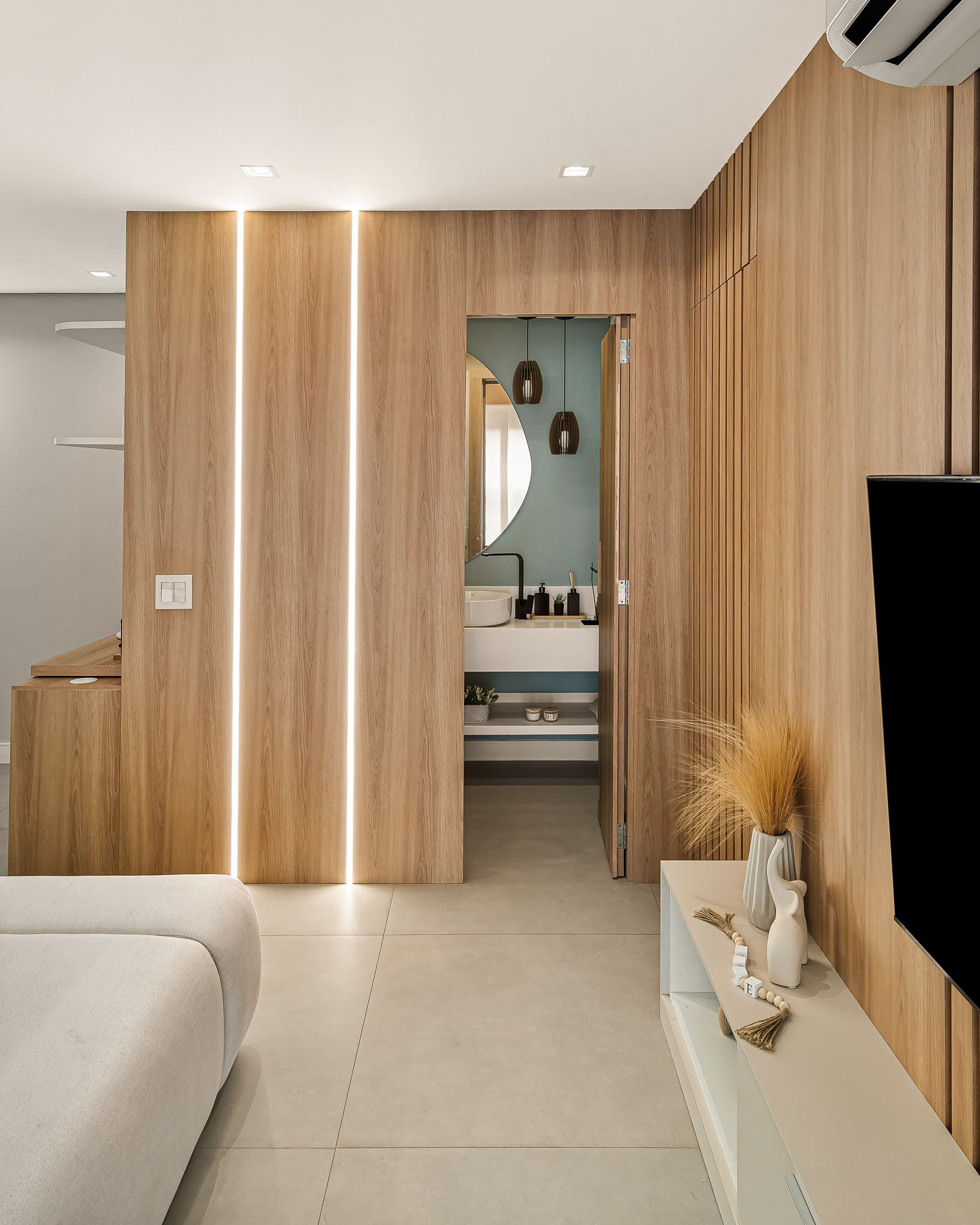 Painel de madeira com porta embutida e passagem para o lavabo azul-esverdeado