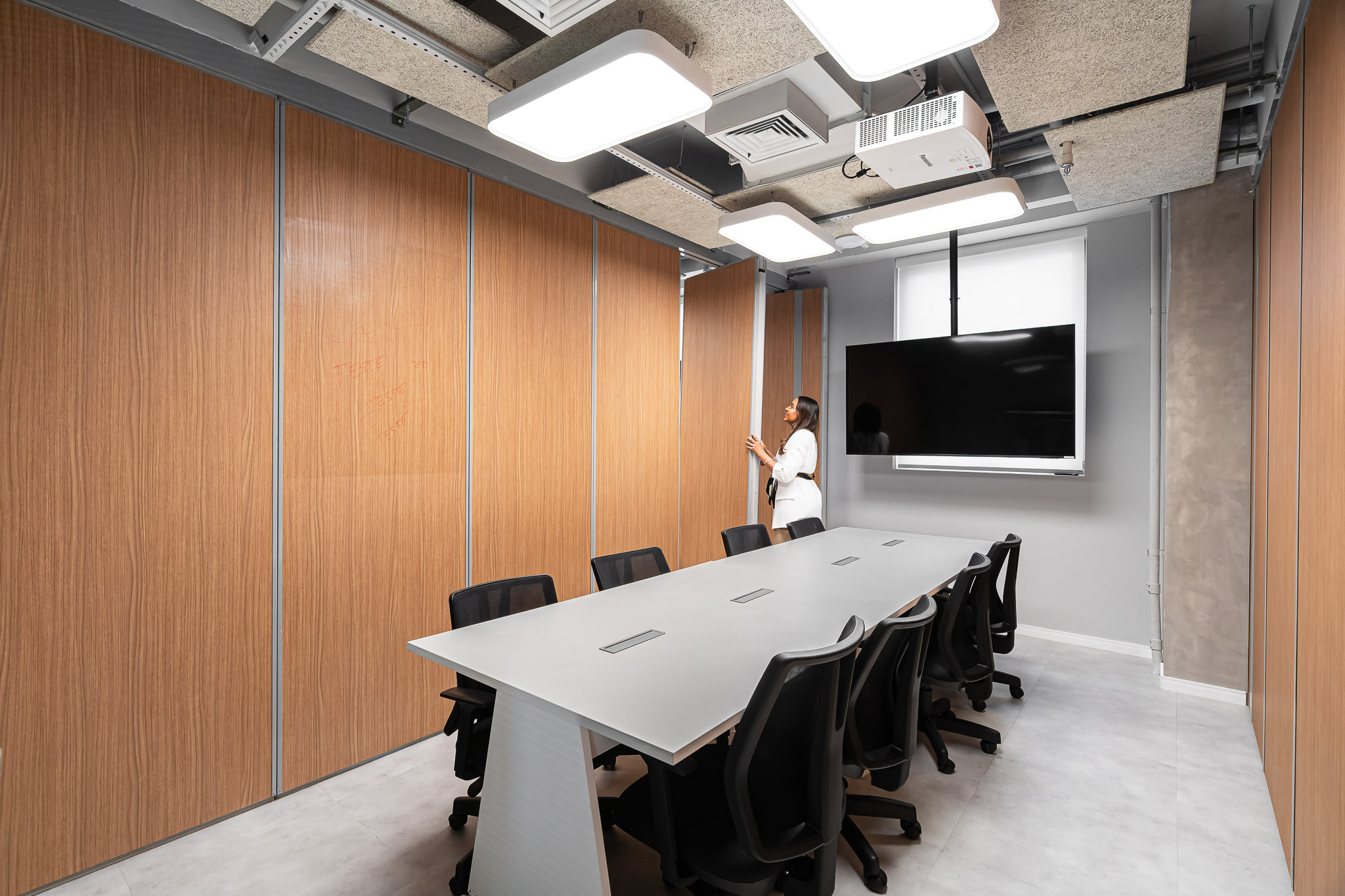 Área de trabalho com baias acolchoadas em couro e painel acústico amarelo