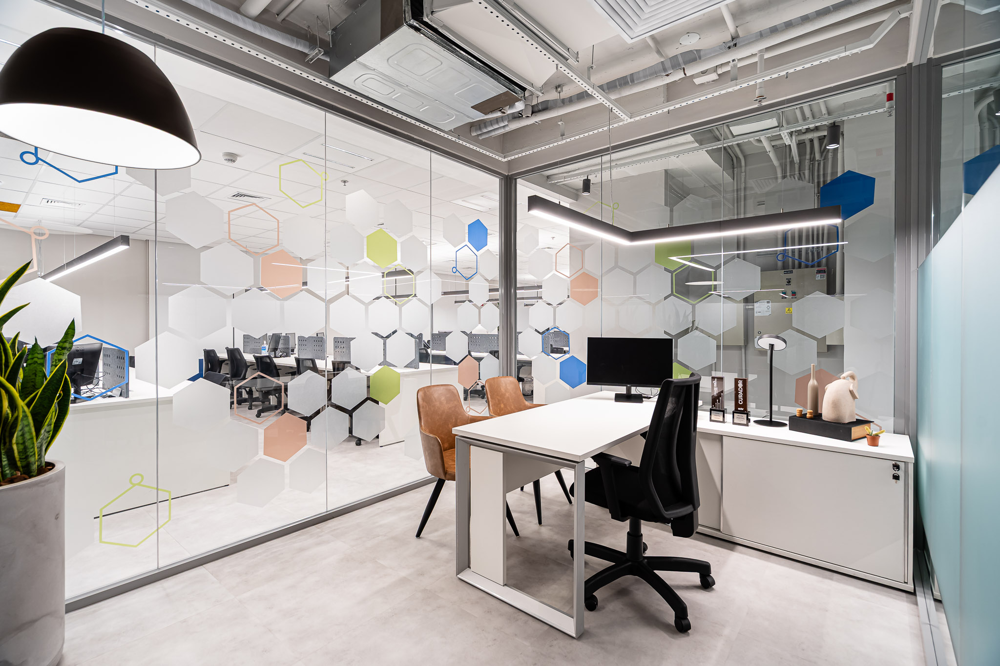 Diretoria com painéis hexagonais coloridos e marcenaria clara