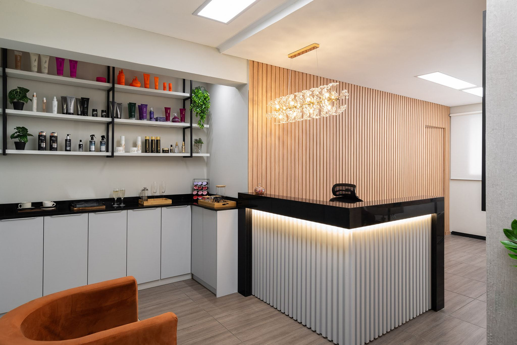Recepção com parede de ripado de madeira e luminária de cristal