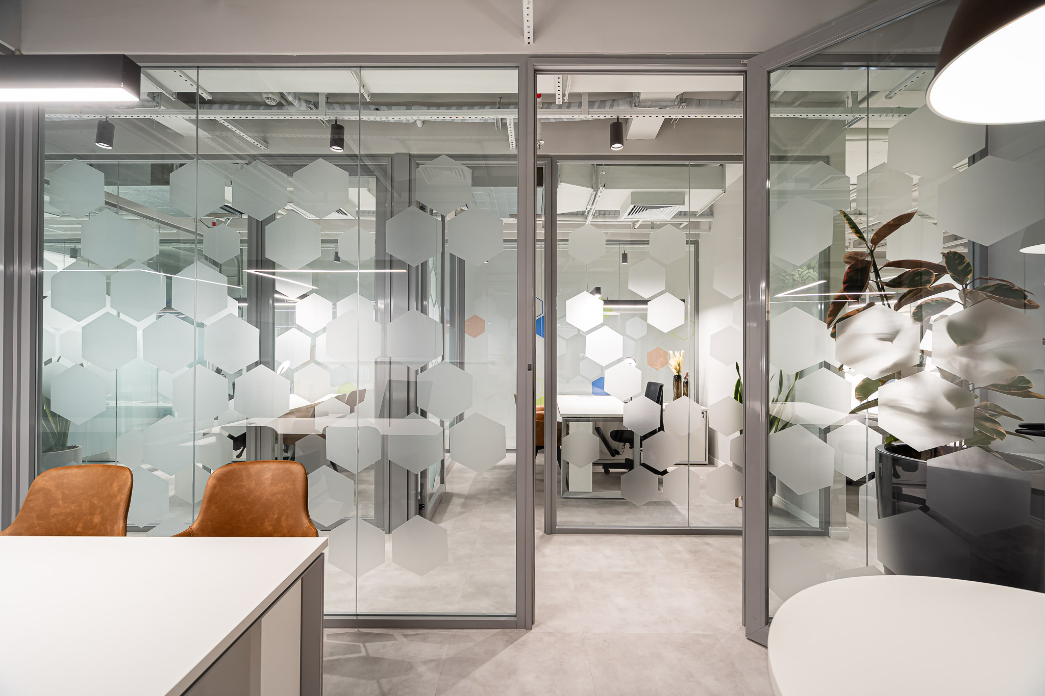 Sala de reunião cercada por vidro com adesivos hexagonais foscos